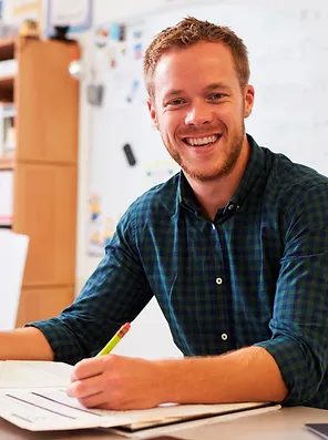 Homem sorrindo fazendo uma anotação de caneta em um caderno