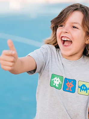 Garoto sorrindo e fazendo o sinal de jóia com as mãos